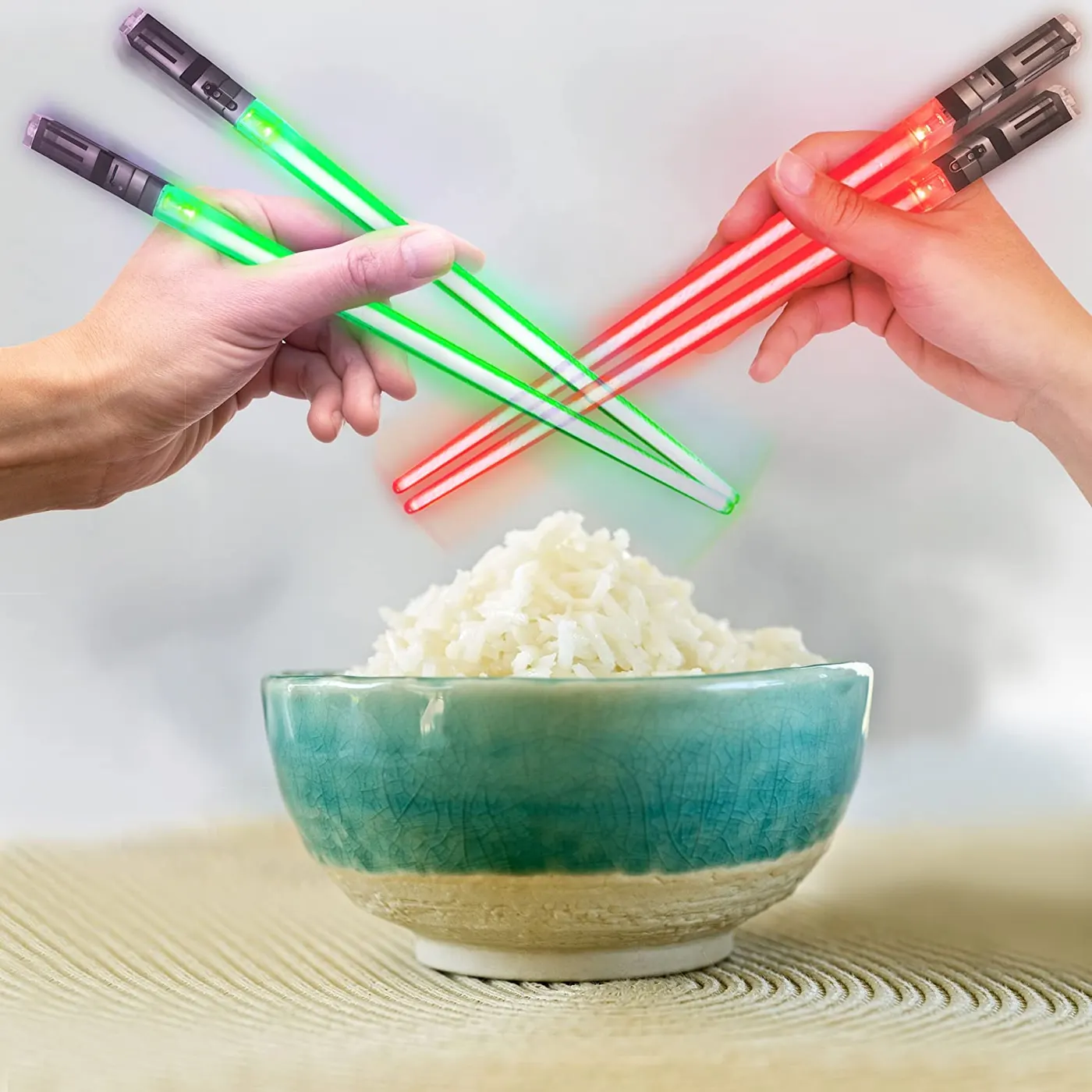 Light-up lightsaber chopsticks glowing next to a bowl of noodles
